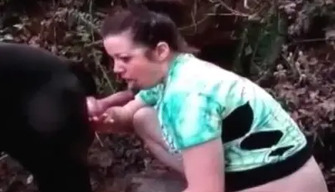 A woman sucks chen to a dog in the forest and jerks off her pussy with a dildo