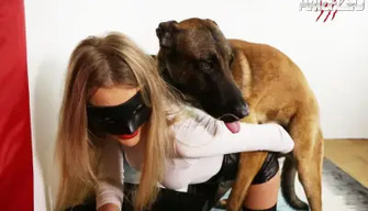 A beautiful blonde in stockings and a leather skirt is engaged in bestiality with a dog